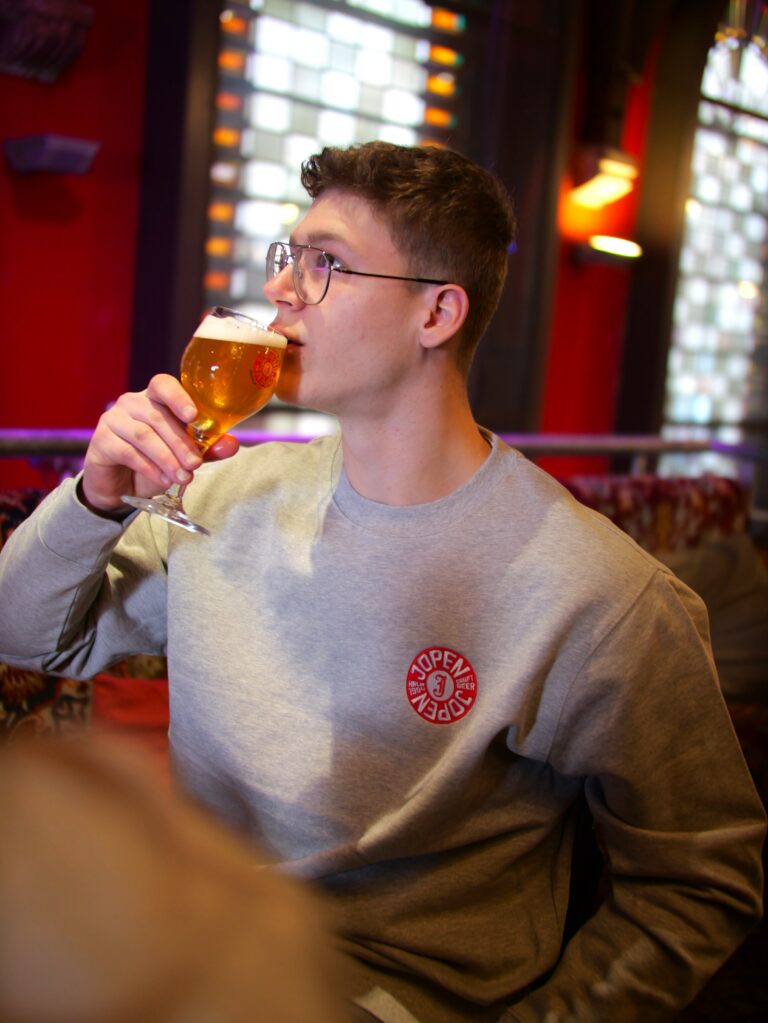 Jongen drinkt Jopenbier in de Jopenkerk met unieke grijze Jopensweater